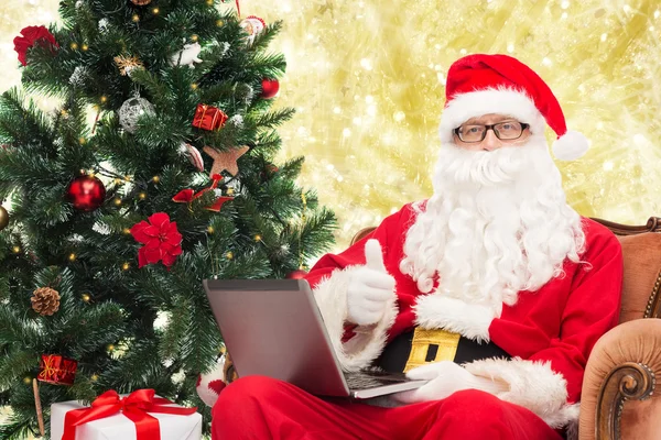 Man in costume of santa claus with laptop — Stock Photo, Image