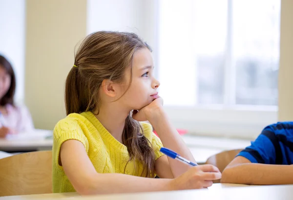 Écolière avec stylo s'ennuyer dans la salle de classe — Photo