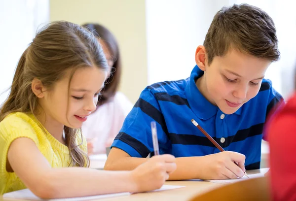 Groep van school-kids schrijven test in klas — Stockfoto