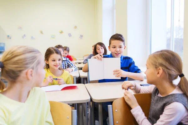 Group of school kids writing test in classroom — Stock Photo, Image