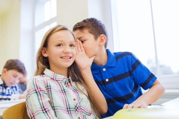 Smiling schoolboy whispering to classmate ear — Stock Photo, Image