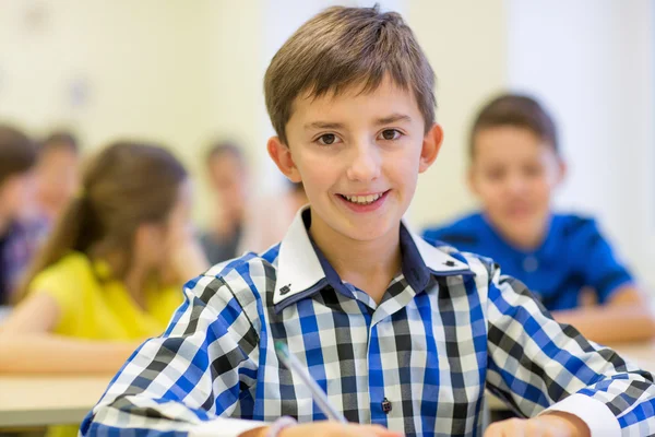 Group of school kids writing test in classroom — Stock Photo, Image