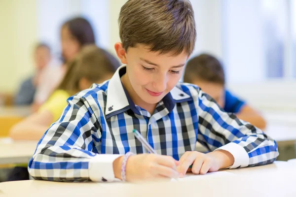 Groep van school-kids schrijven test in klas — Stockfoto