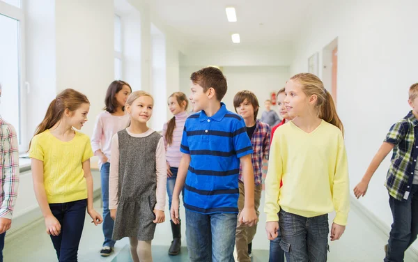 Group of smiling school kids walking in corridor — Stock Photo, Image