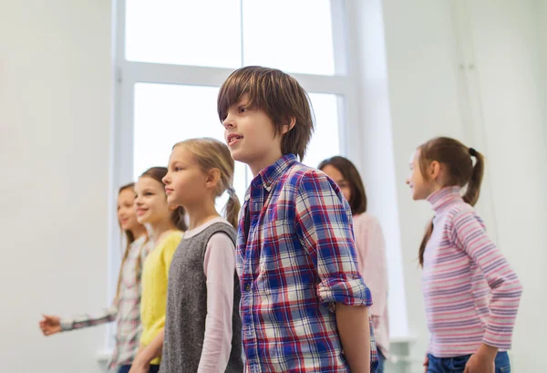 Group of smiling school kids walking in corridor — Stock Photo, Image