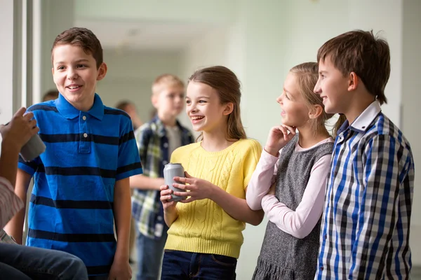 Группа школьников с банками с содовой в коридоре — стоковое фото