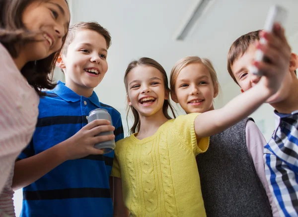 Grupo de niños de la escuela con teléfono inteligente y lata de refresco —  Fotos de Stock