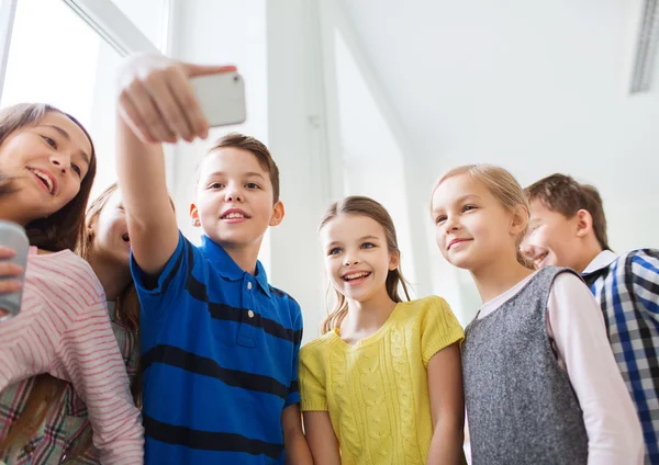 Grupo de escolares tomando selfie con smartphone —  Fotos de Stock