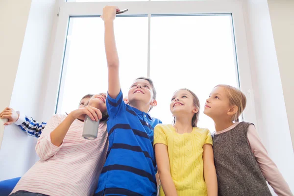 Grupo de niños de la escuela con teléfono inteligente y lata de refresco — Foto de Stock