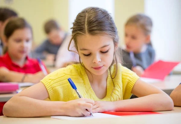 Group of school kids writing test in classroom Royalty Free Stock Images