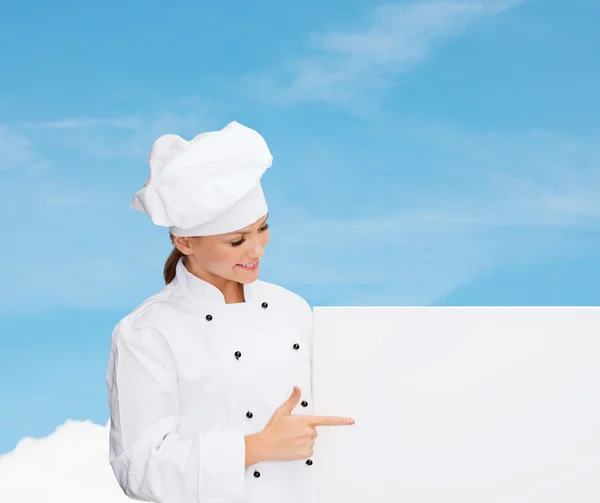 Smiling female chef with white blank board — Stock fotografie