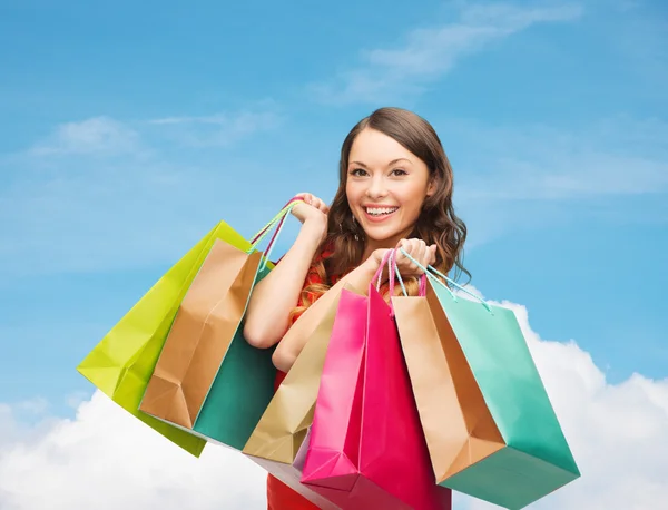 Mulher sorridente com sacos de compras coloridos — Fotografia de Stock