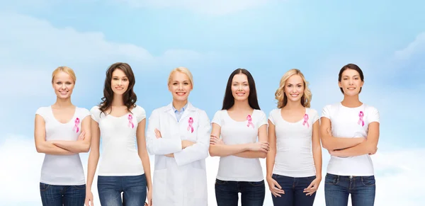 Mujeres sonrientes con cintas de conciencia de cáncer rosa —  Fotos de Stock