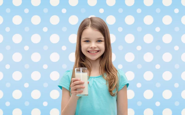 Menina sorridente com copo de leite sobre bolinhas — Fotografia de Stock