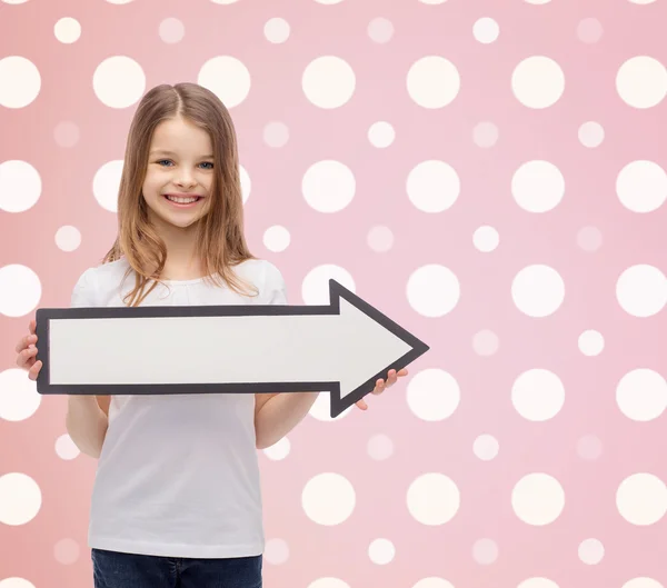 Menina sorrindo com seta em branco apontando para a direita — Fotografia de Stock