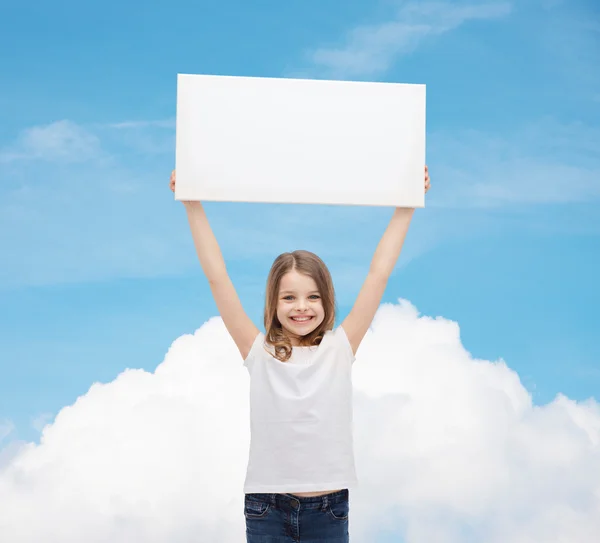 Sonriente niña sosteniendo en blanco tablero blanco — Foto de Stock