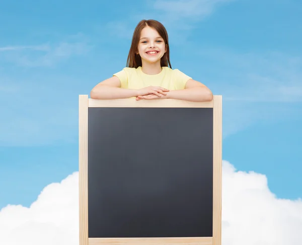 Happy little girl with blank blackboard — Stock Photo, Image