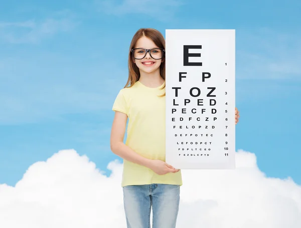 Little girl in eyeglasses with eye checking chart — Stock Photo, Image