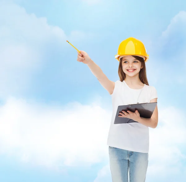 Petite fille souriante en hardhat avec presse-papiers — Photo