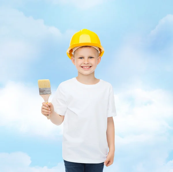 Smiling little boy in helmet with paint brush — Stock Photo, Image