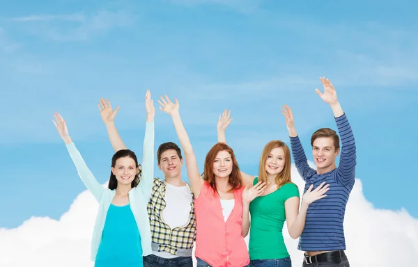 Grupo de estudiantes sonrientes saludando con las manos — Foto de Stock