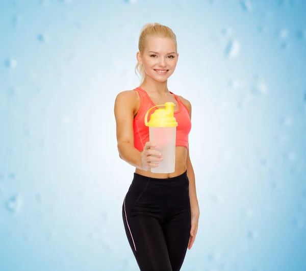 Lächelnde sportliche Frau mit Protein-Shake-Flasche — Stockfoto