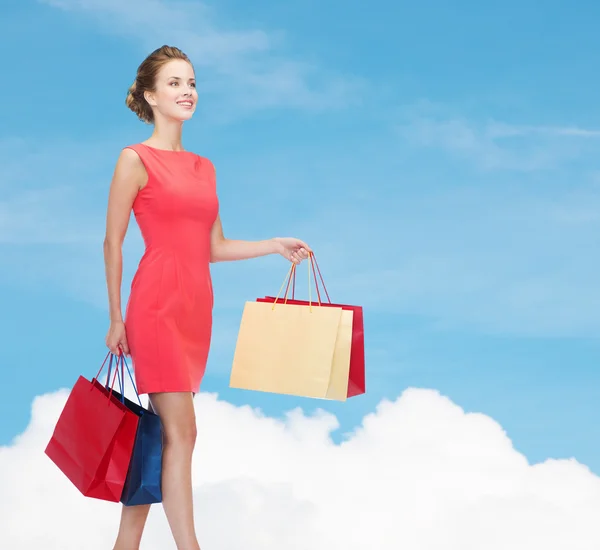 Usmívající se elegantní žena v šatech s nákupní tašky — Stock fotografie