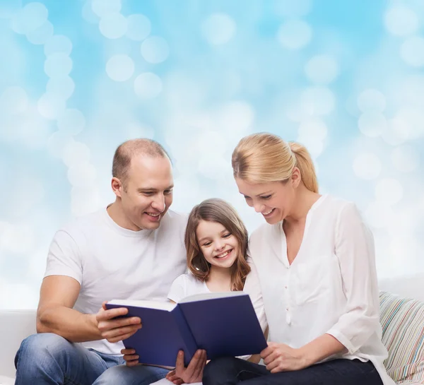 Famille heureuse avec livre à la maison — Photo