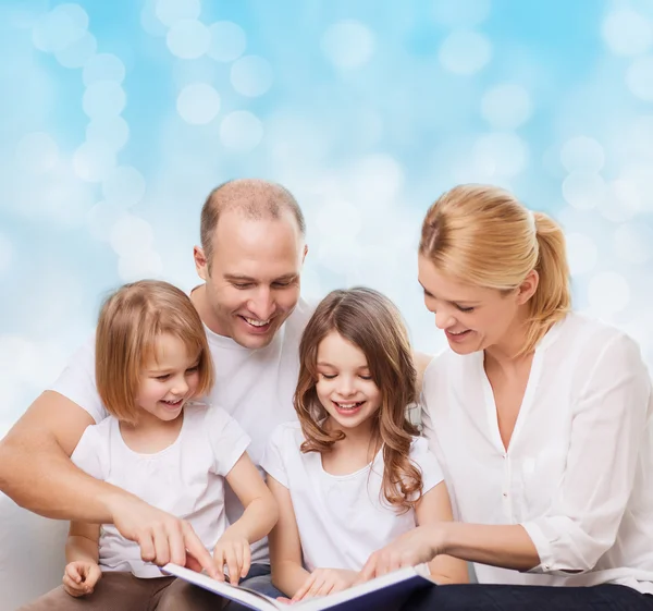 Família feliz com livro em casa — Fotografia de Stock