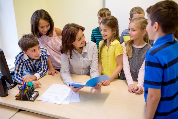 Group of school kids with teacher in classroom — Stock Photo, Image