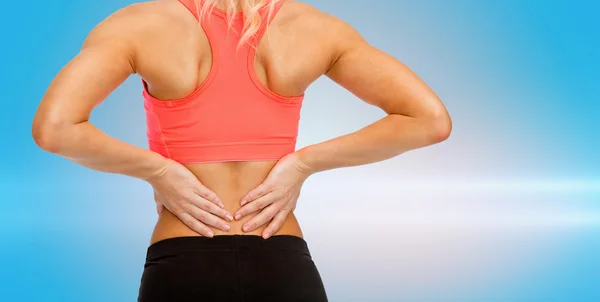 Close up of sporty woman touching her back Stock Picture