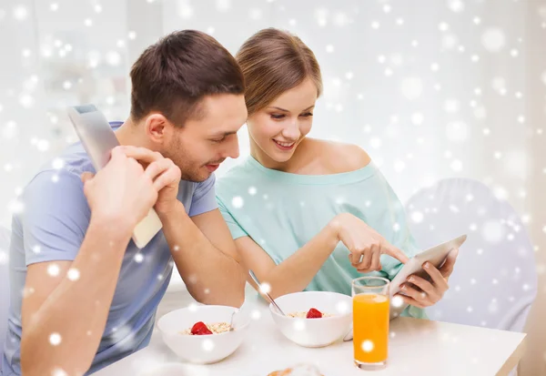 Casal sorridente com tablet pc tomando café da manhã — Fotografia de Stock