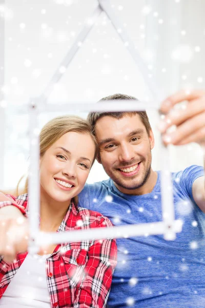 Casal sorrindo com casa feita de fita métrica — Fotografia de Stock