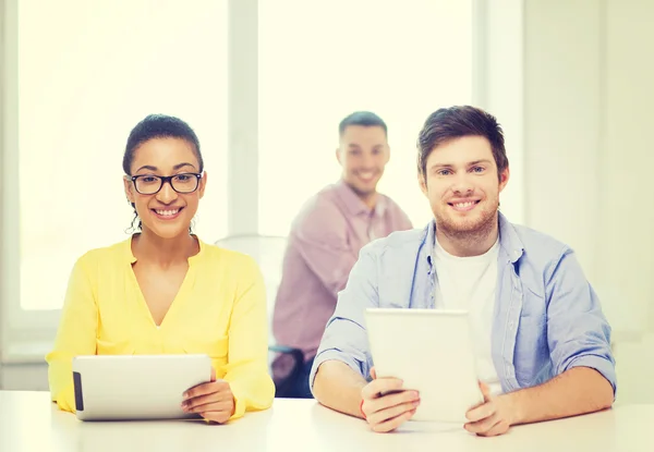 Glimlachend team met tablet pc-computers op kantoor — Stockfoto