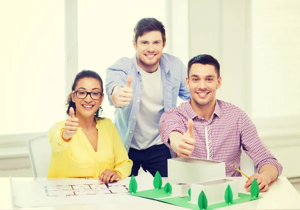 Arquitectos sonrientes trabajando en la oficina — Foto de Stock