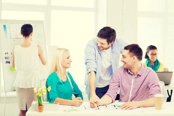 Diseñadores de interiores sonrientes trabajando en la oficina — Foto de Stock