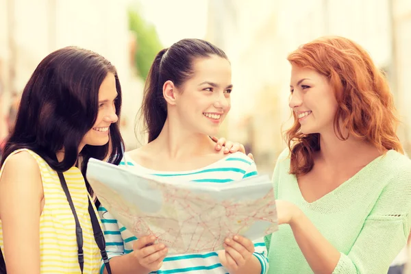 Meninas adolescentes sorridentes com mapa e câmera — Fotografia de Stock
