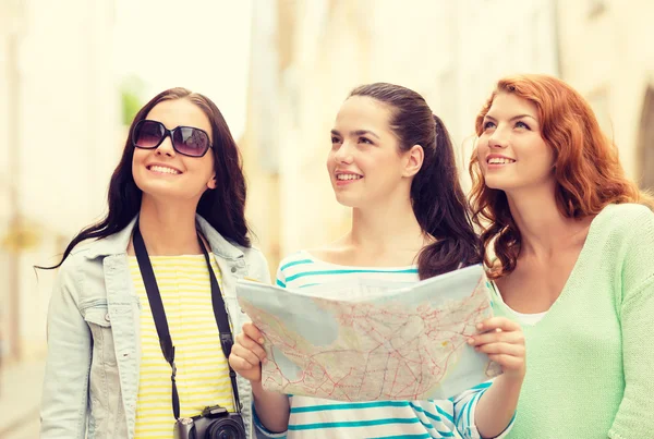 Meninas adolescentes sorridentes com mapa e câmera — Fotografia de Stock