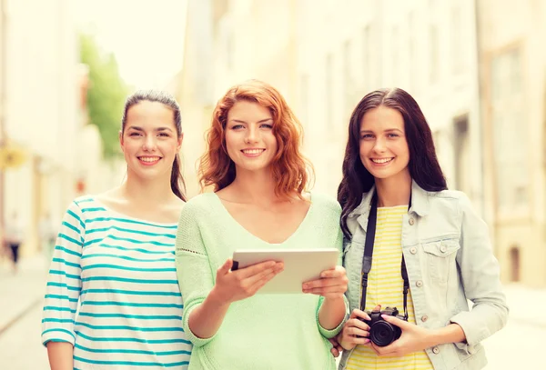 Chicas adolescentes sonrientes con la tableta PC y la cámara — Foto de Stock