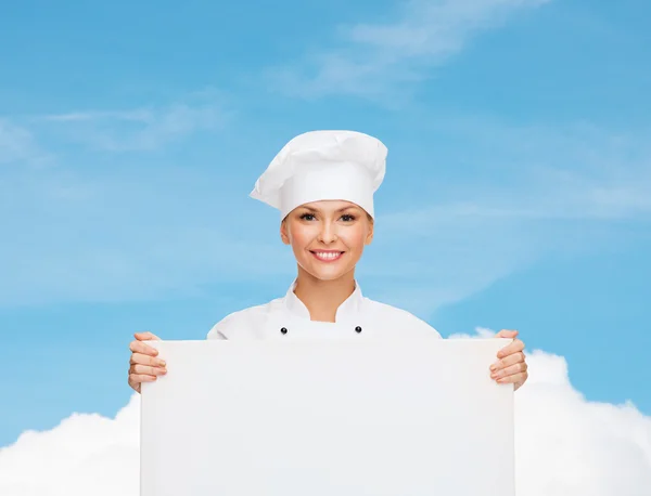Uśmiechnięta kobieta kucharz z biały deska — Zdjęcie stockowe