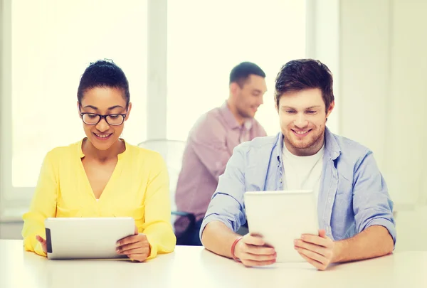 Équipe souriante avec tablette PC au bureau — Photo