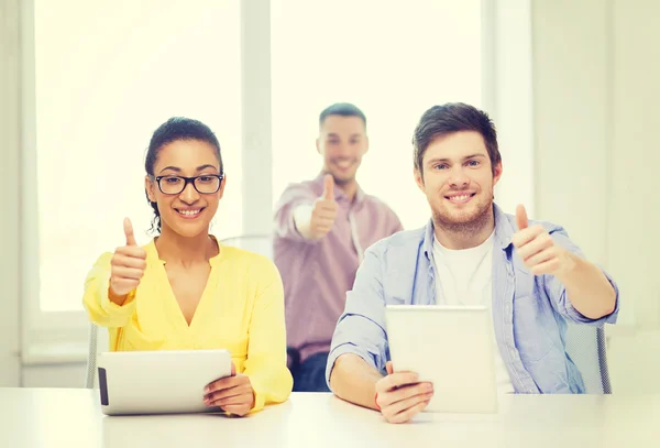 Équipe souriante avec tablette PC au bureau — Photo