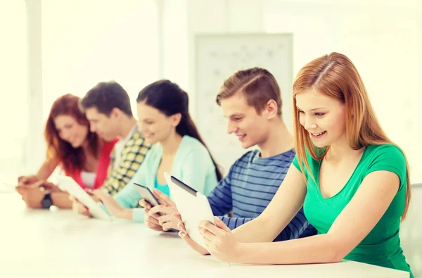 Estudiantes sonrientes con Tablet PC en la escuela —  Fotos de Stock