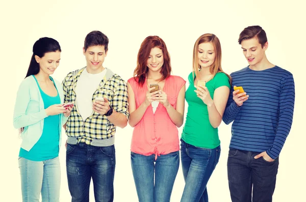 Estudantes sorridentes com smartphones — Fotografia de Stock