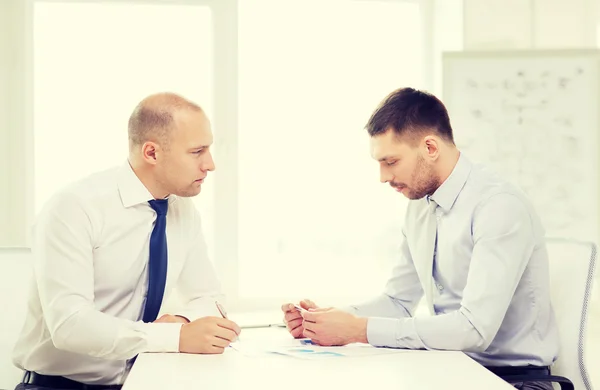 Two serious businessman with papers in office — Stock Photo, Image