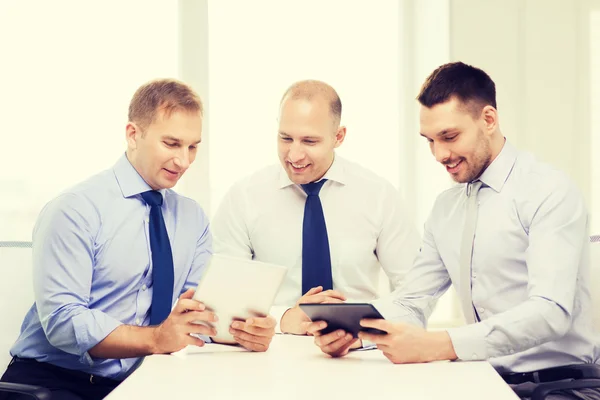 Trois hommes d'affaires souriants avec tablette PC au bureau — Photo