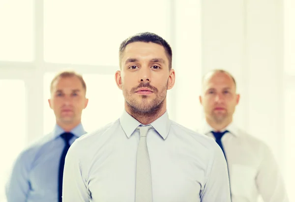 Hombre de negocios serio en la oficina con el equipo en la espalda — Foto de Stock