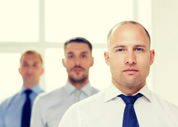 Hombre de negocios serio en la oficina con el equipo en la espalda — Foto de Stock