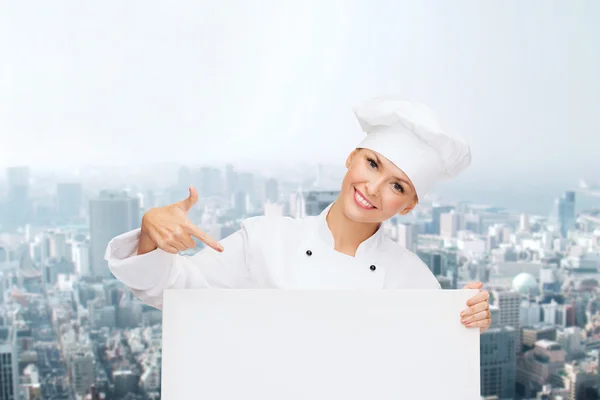 Smiling female chef with white blank board — ストック写真