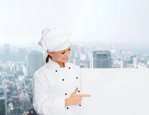 Smiling female chef with white blank board — Stock Photo, Image